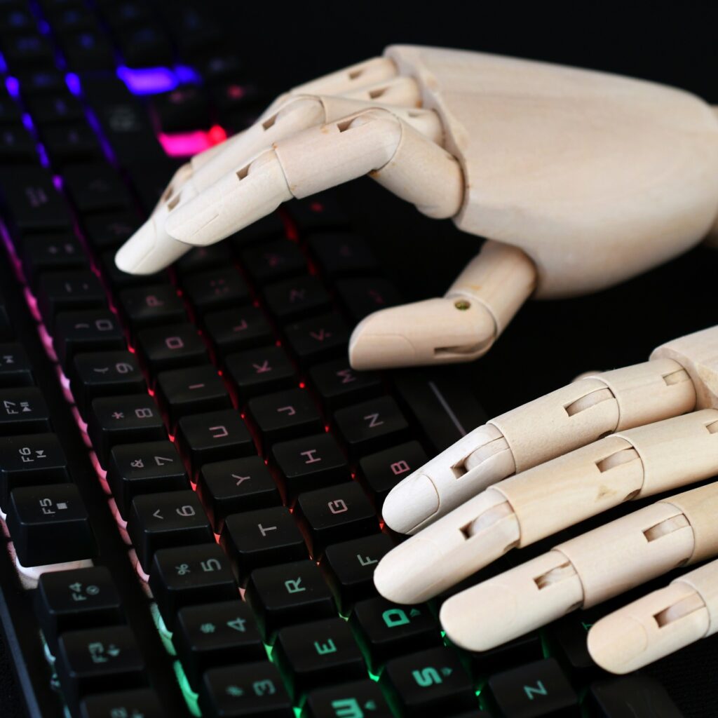 AI artificial intelligence concept - robot hands typing on lit keyboard