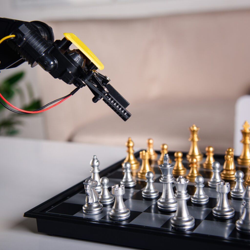 Closeup yellow robot arm playing move chess on chessboard