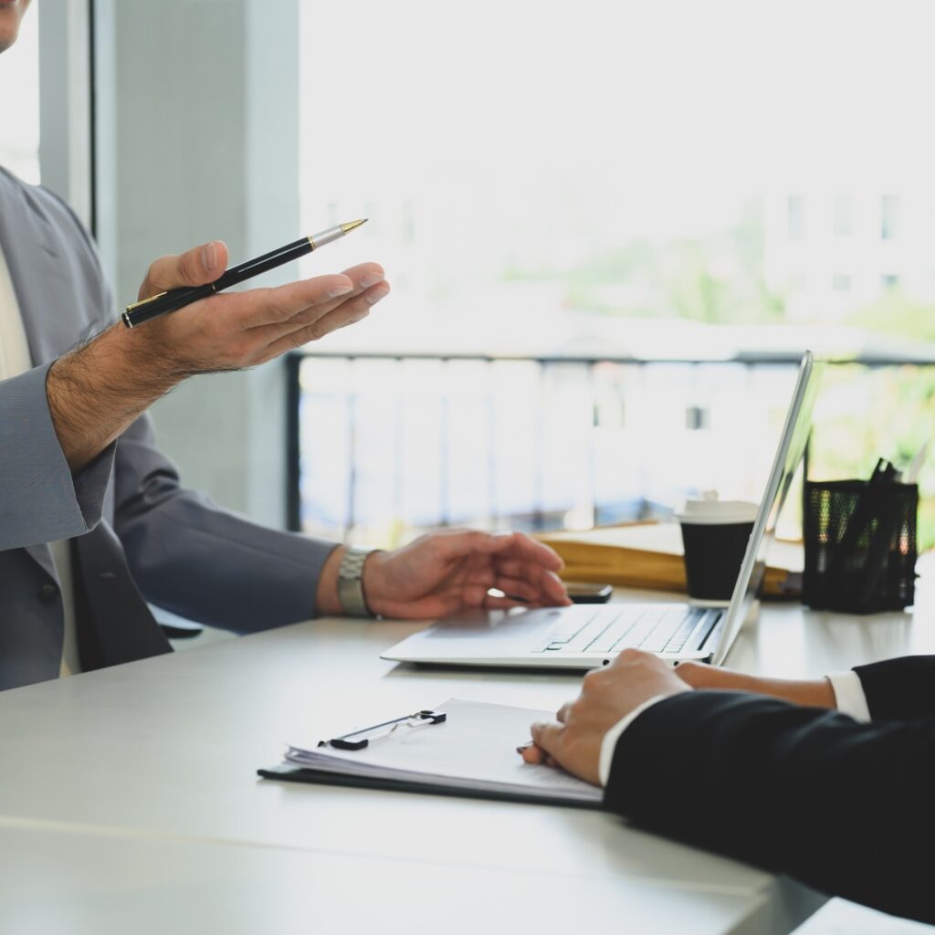 Cropped shot business advisor explaining the contract, offering it for the client to sign.