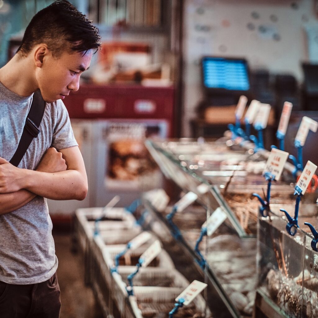 Young asian man is choosing products at market