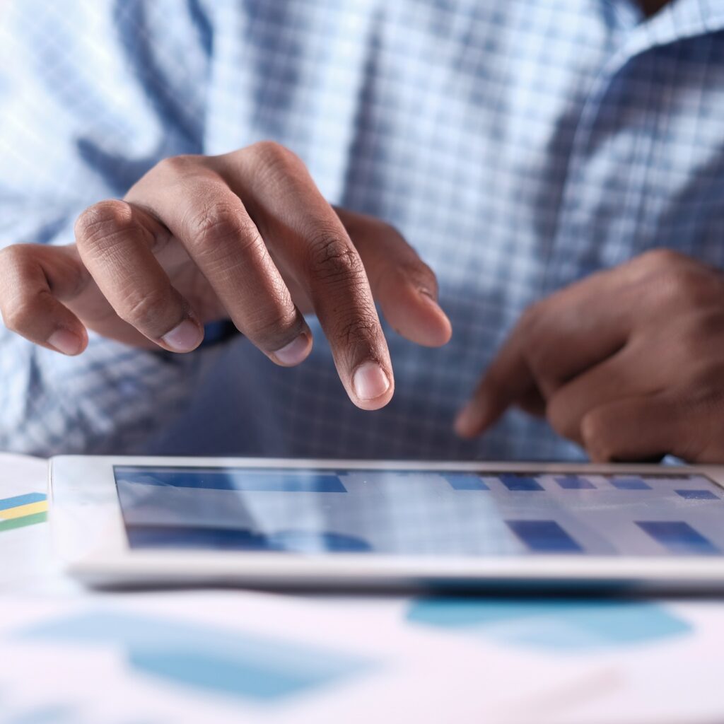 A skilled professional is using a tablet for detailed data analysis and insights